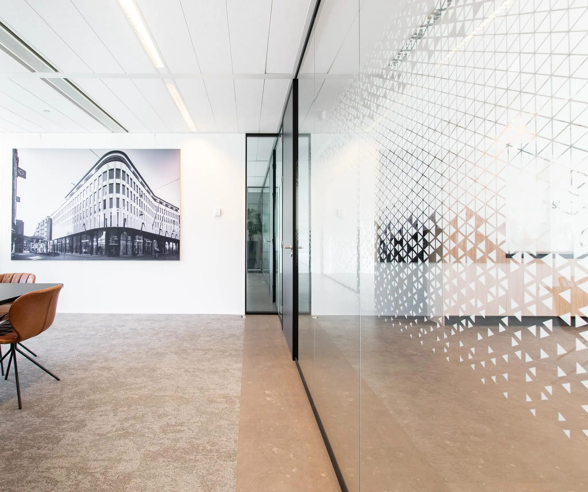 Moderne kantoorruimte met glazen wanden en een grote zwart-witfoto van de Grote Marktstraat aan de muur.